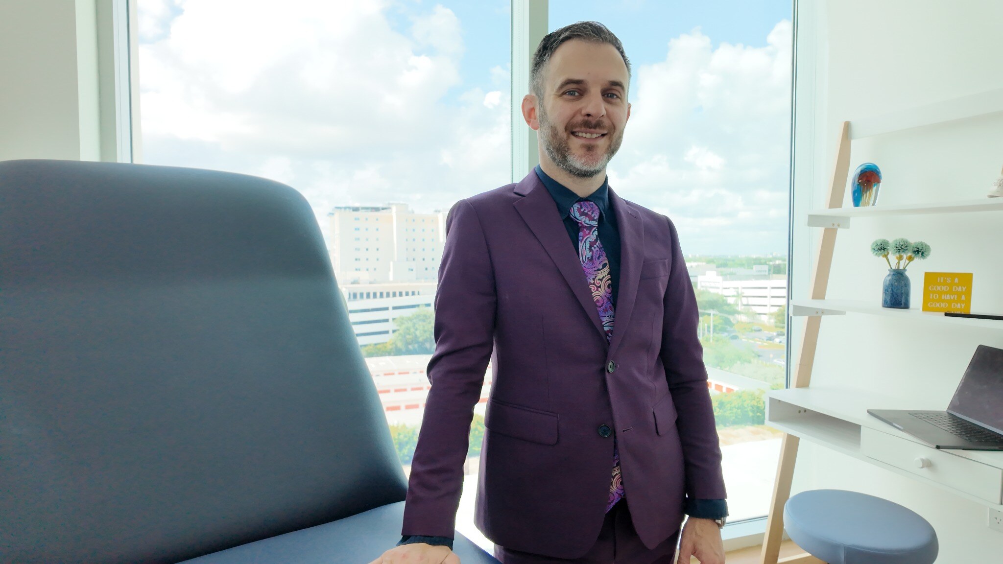 Dr. Stacey in his purple suit in the consultation room.