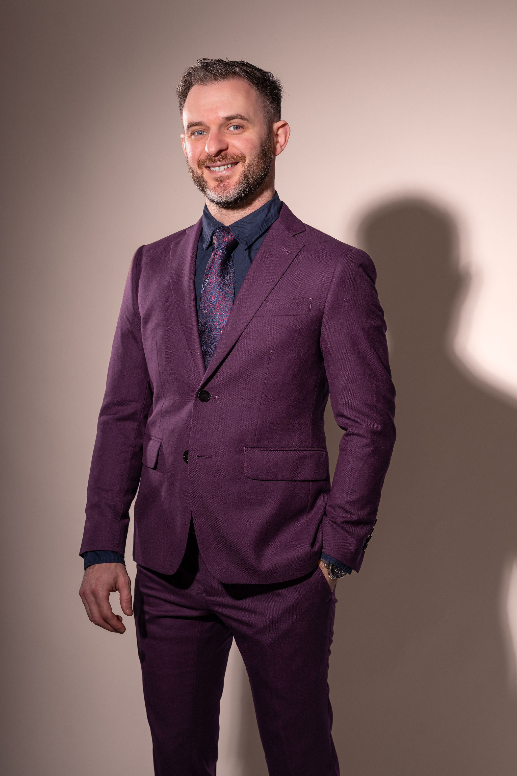 Dr. Stacey standing in his purple suit.