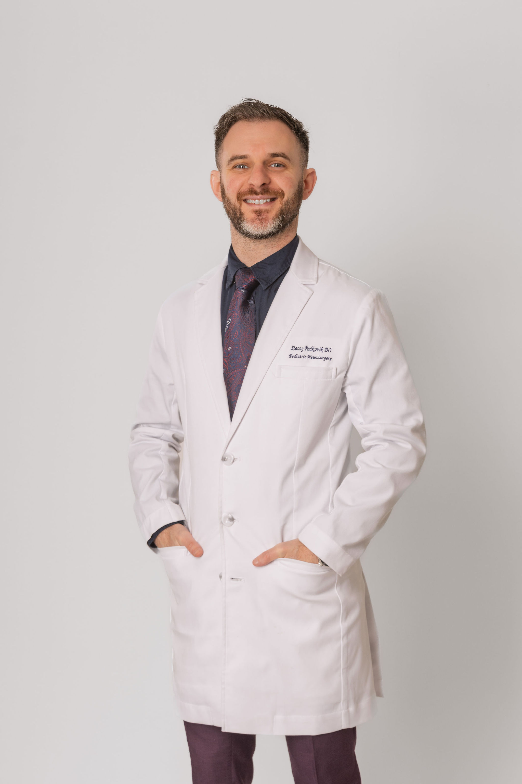 Dr. Stacey Podkovik in his white coat over his purple suit.