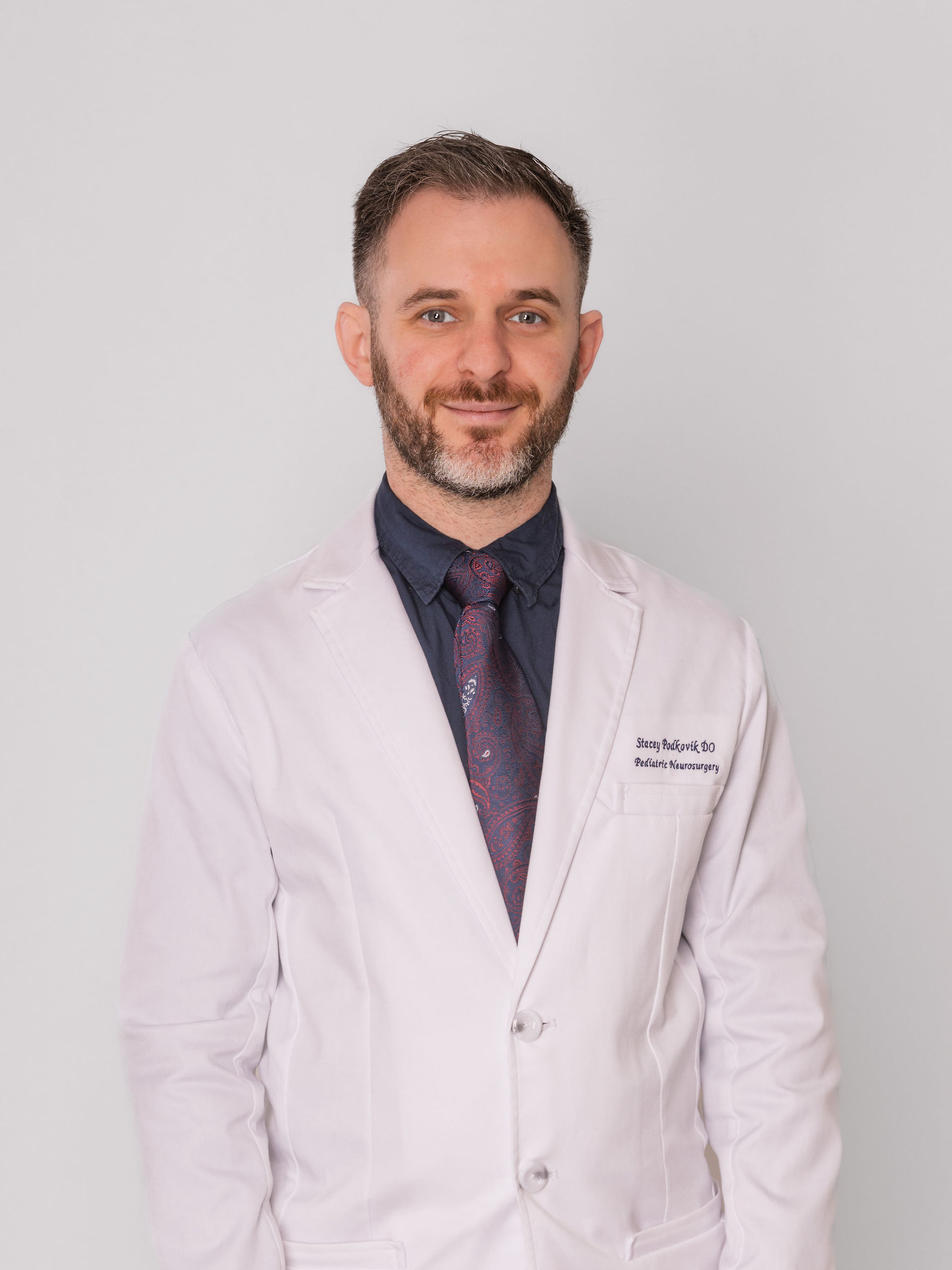 Dr. Stacey Podkovik in a white coat over his purple suit.