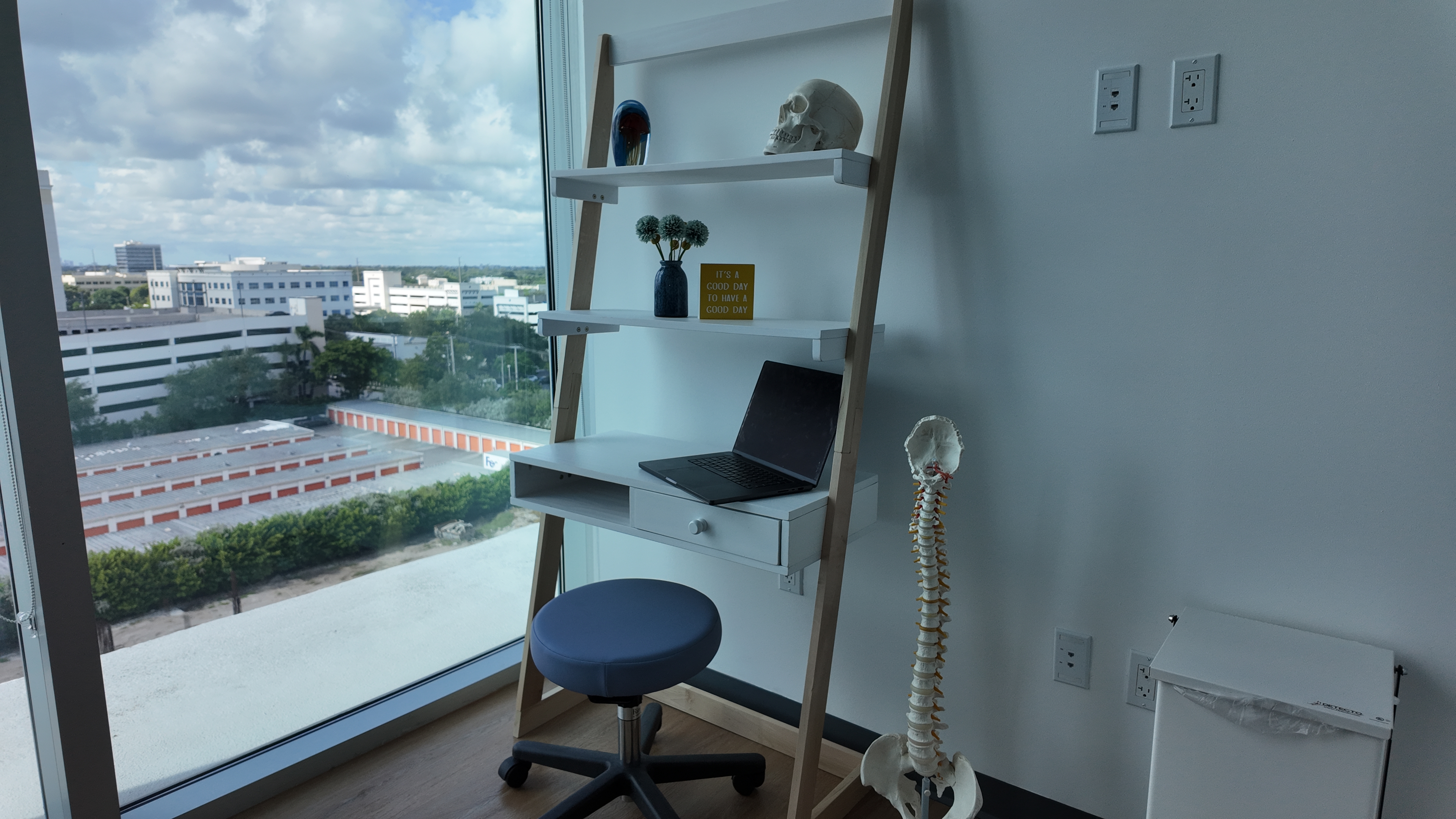 The consultation room with a chair, desk and anatomical models.
