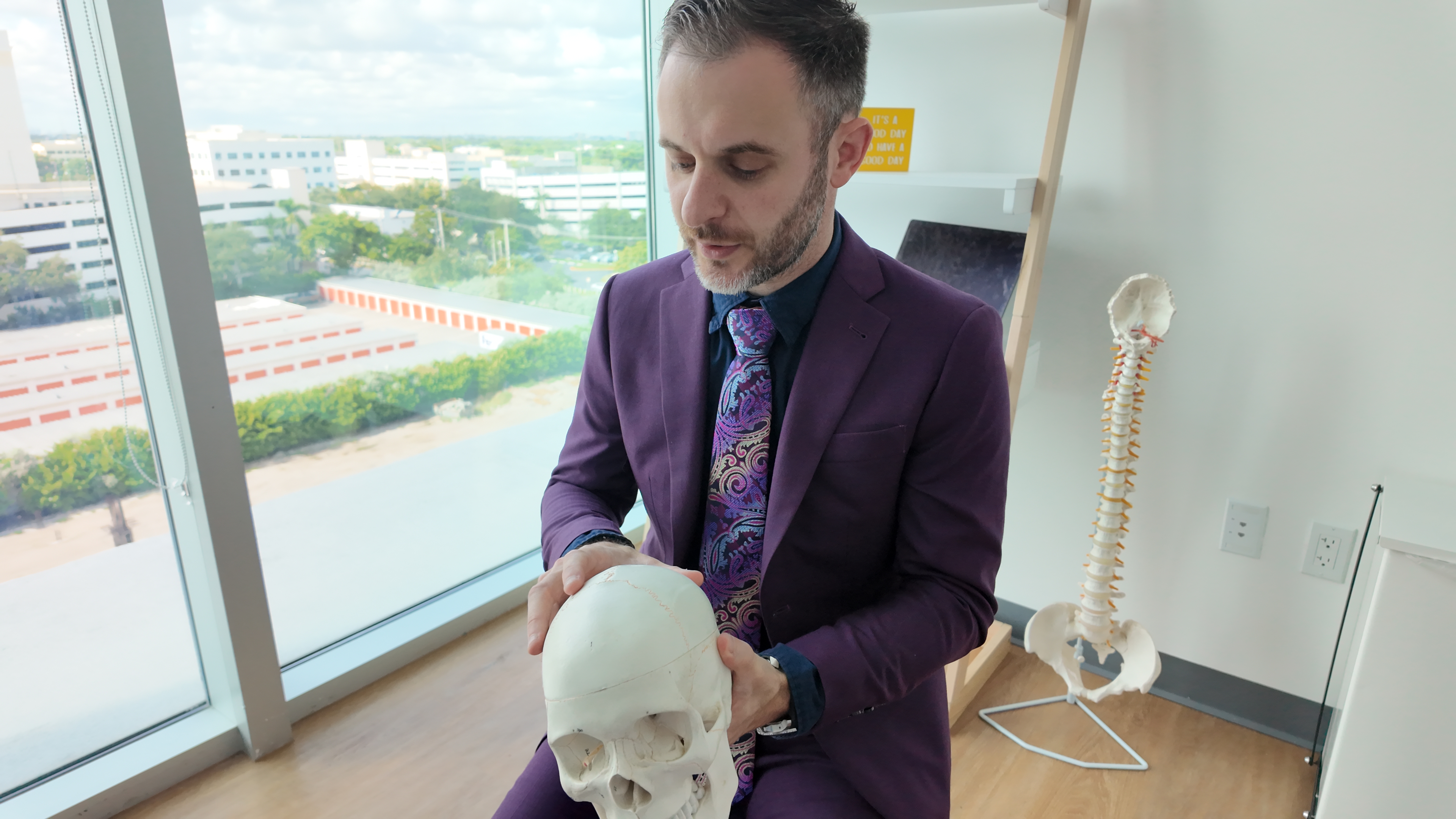 Dr. Stacey in his purple suit explaining a skull model.