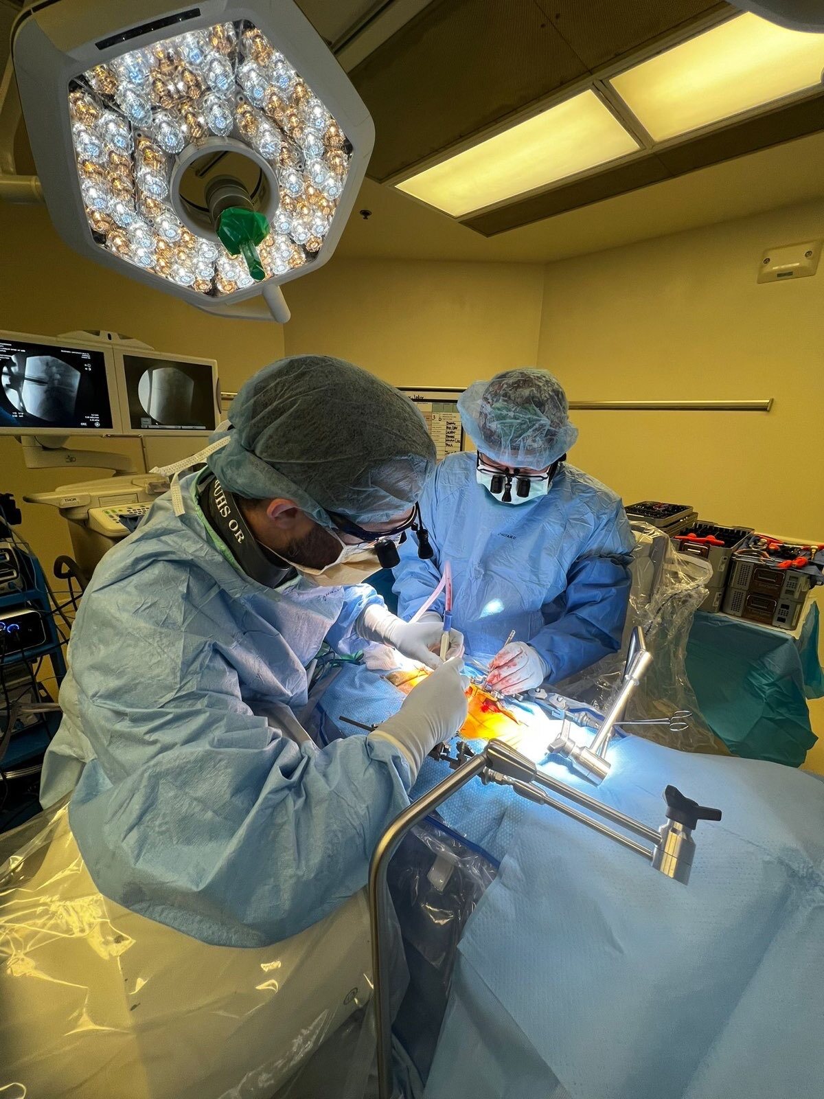 Two members of the surgical team working together in the operating room.