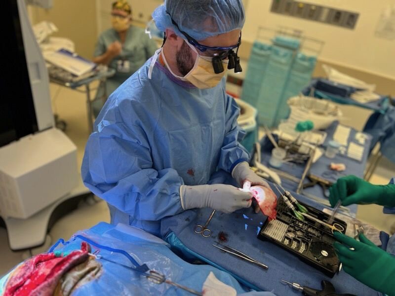 A surgeon and an assistant working with instruments in the operating room.